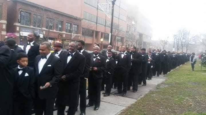 Long line of men and boys in tuxedos marching