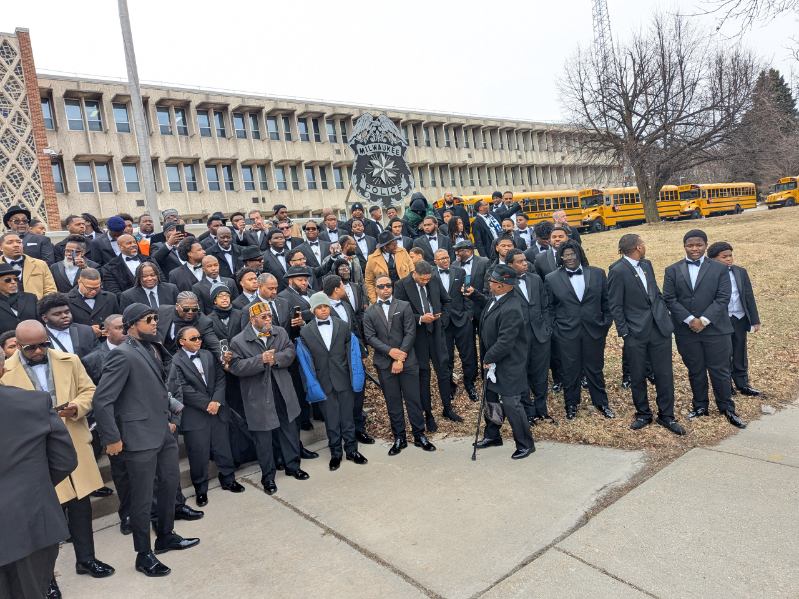 Men in tuxedos joined in a circle